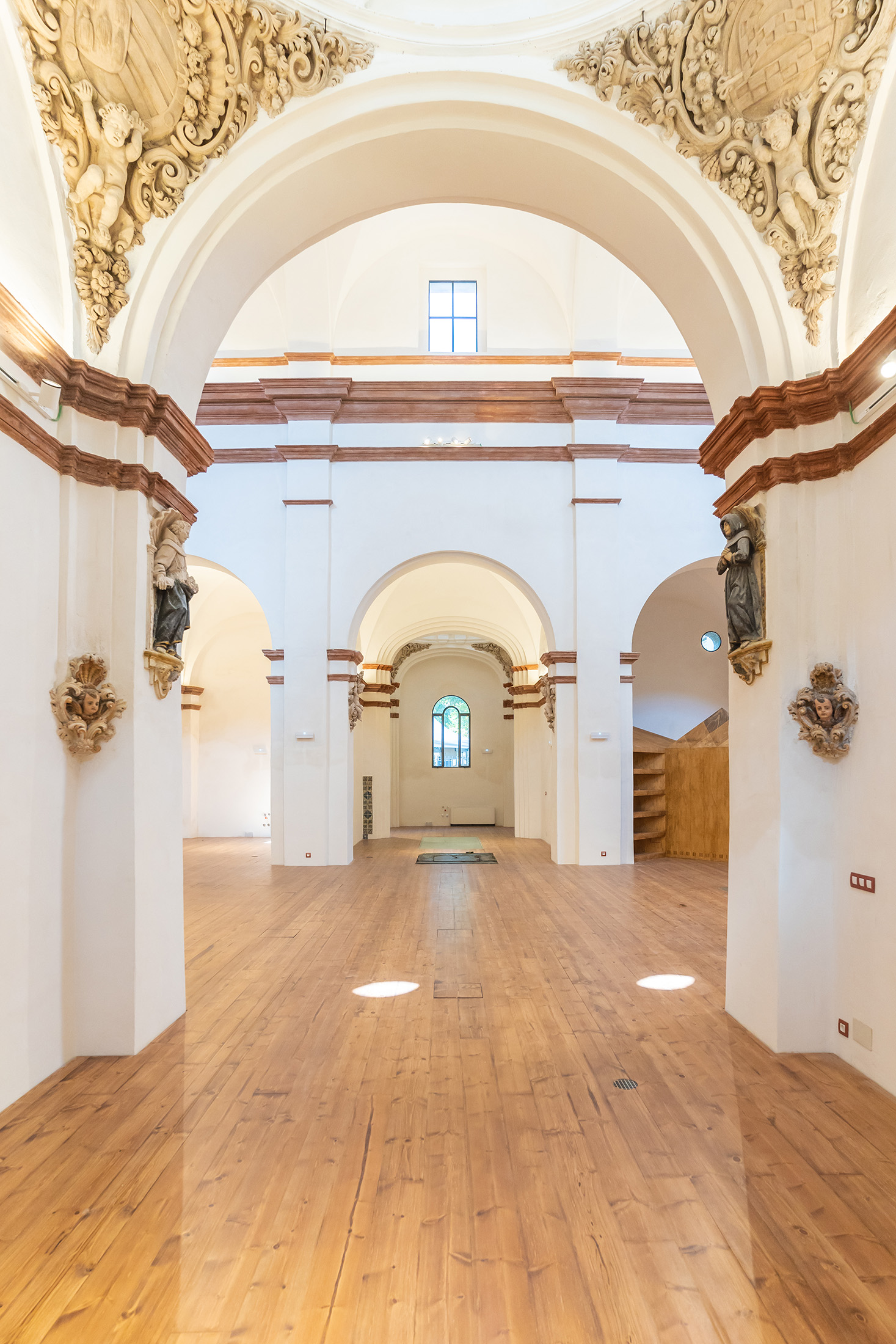 Vista frontal y simétrica de la nave central destacando los arcos y cornisas restauradas